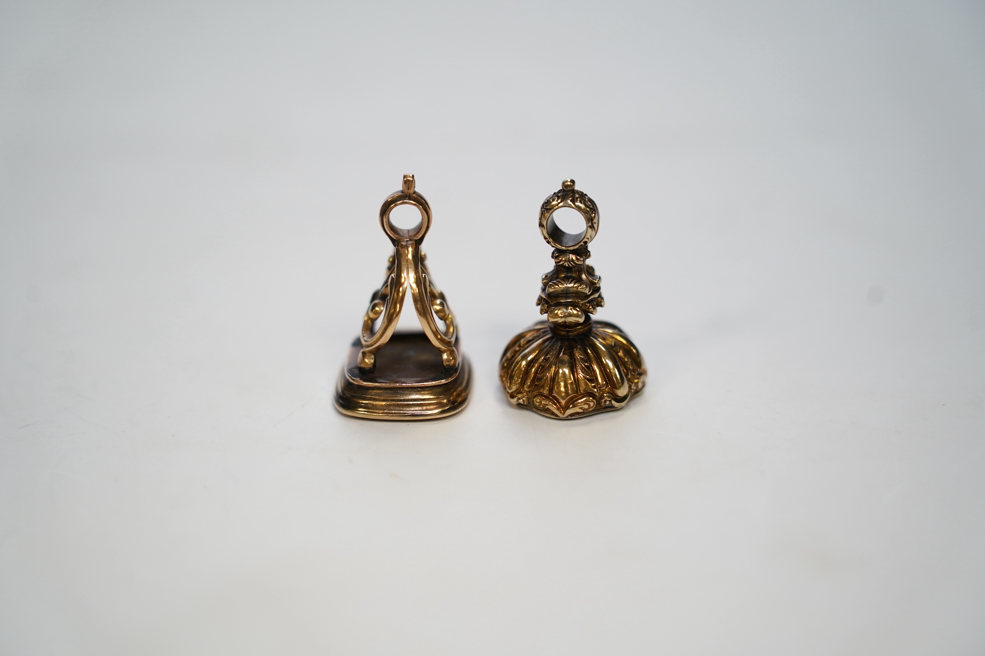 Two 19th century yellow metal overlaid and chalcedony set fob seals, largest 28mm. Condition - fair